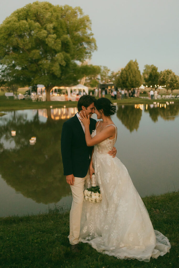 Bride and groom portrait by pond at sunset