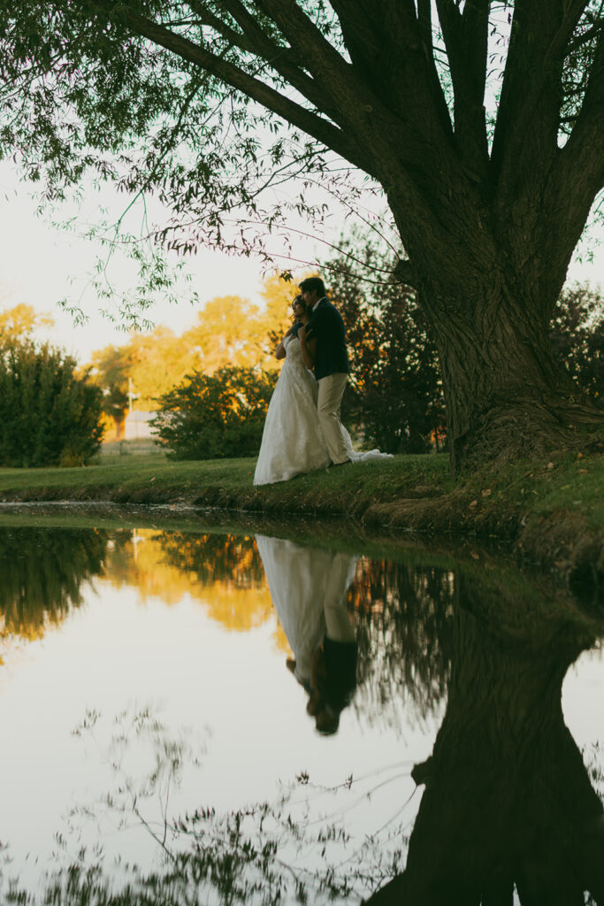 Bride and groom portrait with reflection in pond