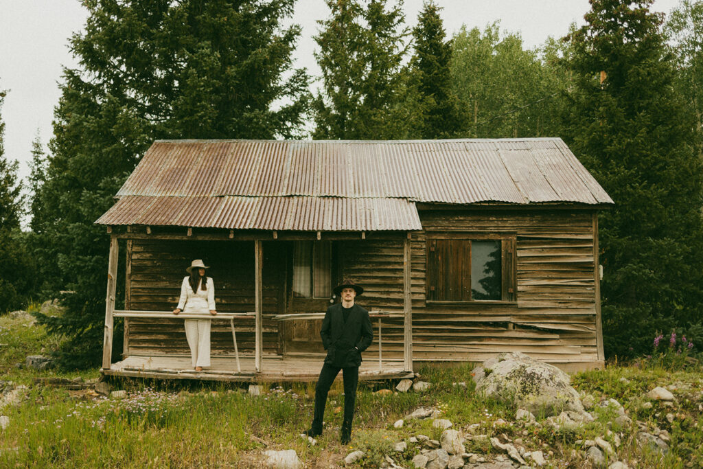 A couple on their elopement day in Telluride, CO looking at each other in front of an old wooden cabin