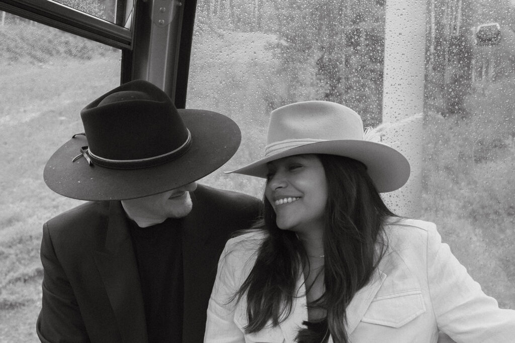 A couple on their elopement day in Telluride, CO riding the gondola with rain drops on the glass