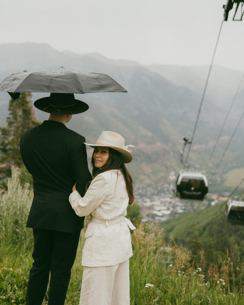 A couple on their elopement day in Telluride, CO at an overlook with the town, mountains, and gondola in the background