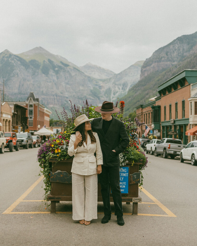 A couple on their elopement day standing in the middle of the street in Telluride, CO with a mountain view 