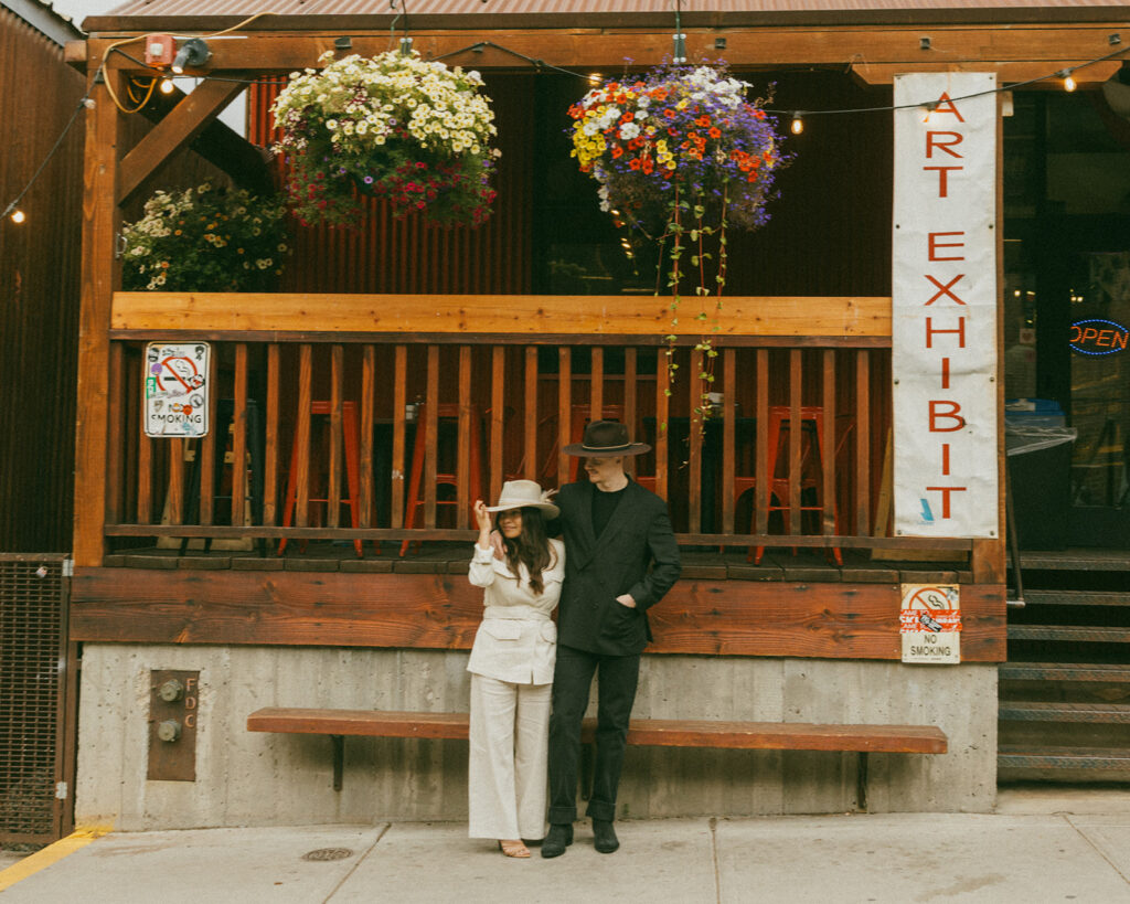 A couple on their elopement day in front of a cafe