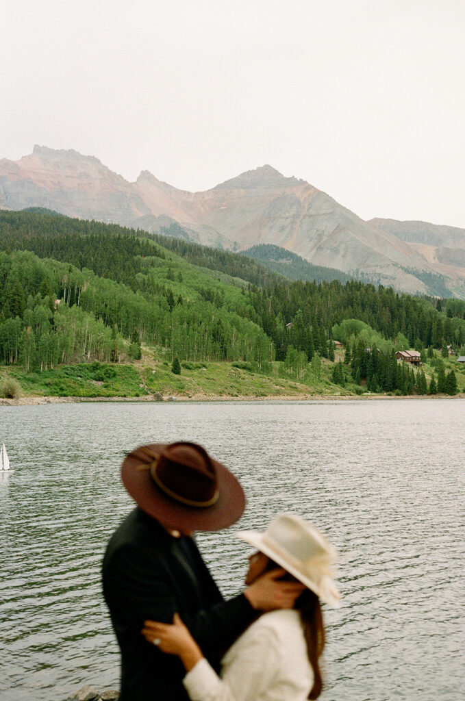 A couple on their elopement day in Telluride, CO looking at each other in front of Trout Lake and the surrounding mountains