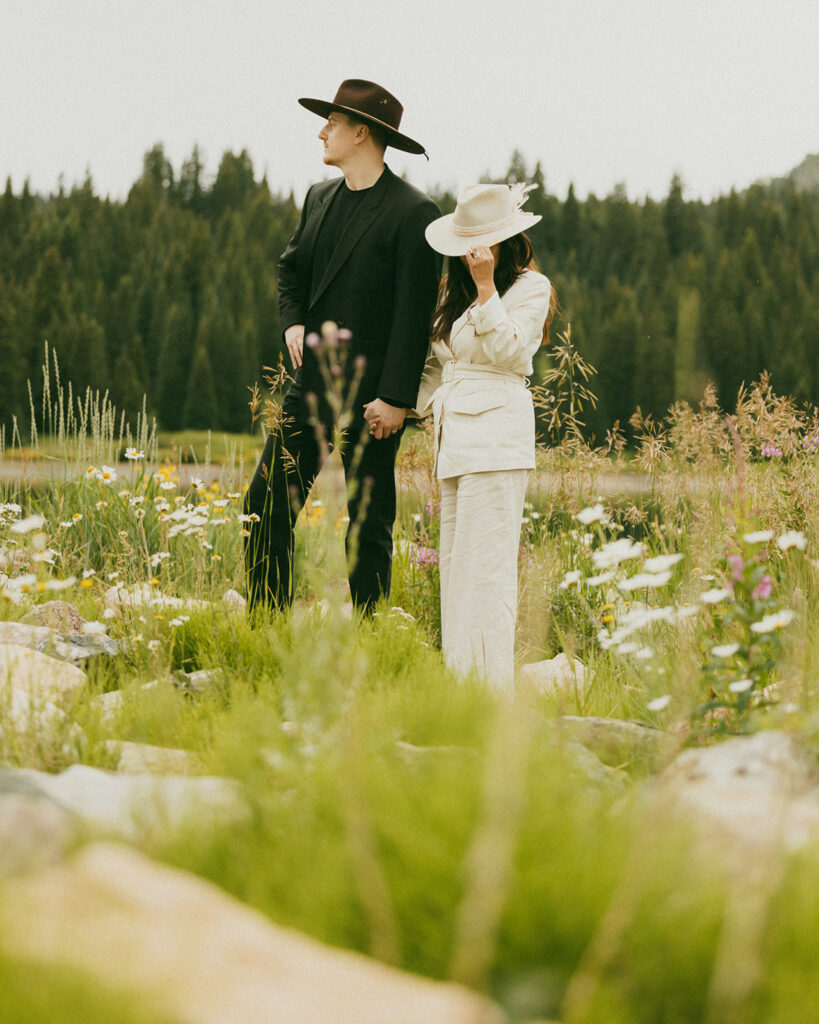 A couple on their elopement day in Telluride, CO posing in the middle of a wildflower field 