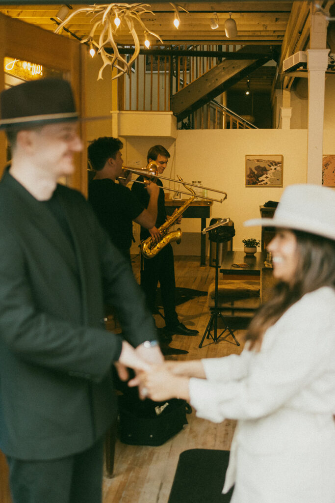 A couple on their elopement day dancing in front of a jazz band