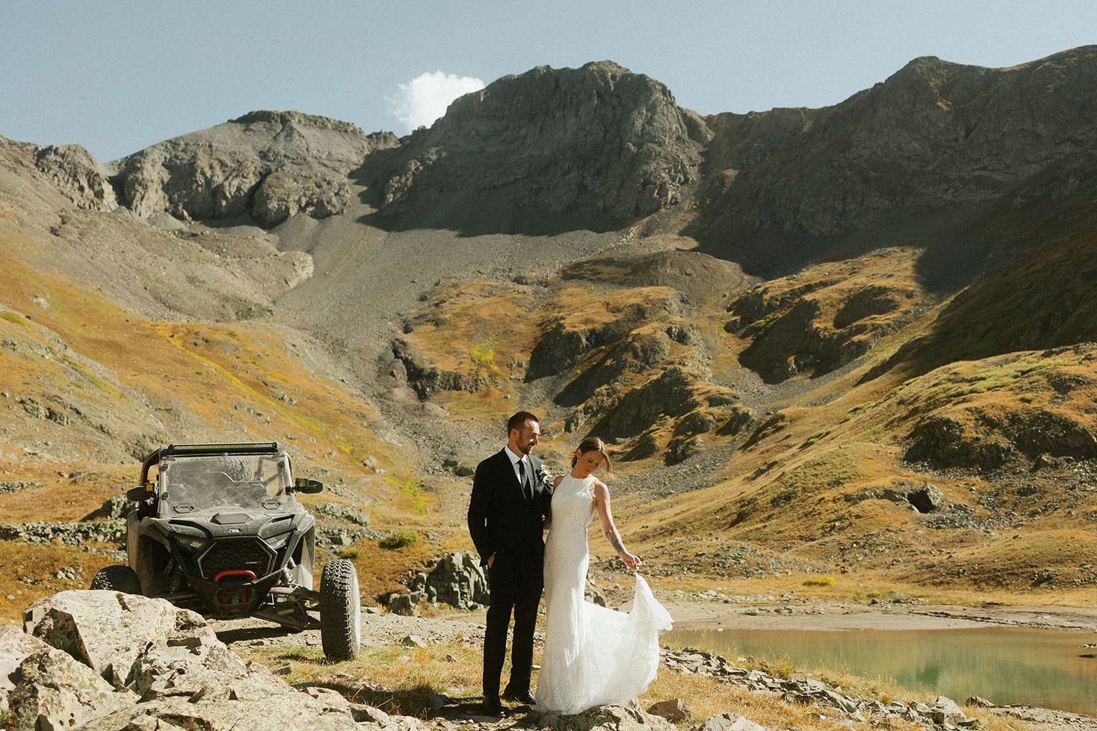 A couple on their elopement day with their off-road vehicle and a mountain view